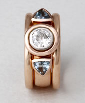 Three stone ring in rose gold with a 1ct diamond and two trilliant cut Aqua-marines.